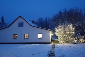 A snow-covered house with a visible window and a pathway leading to the entrance. - Holiday apartment with 2 bedrooms (Putbus \/ OT Güstelitz)