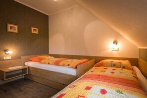 A bedroom with two beds, wooden headboards, and bedside tables with lamps. - in the Martina apartment building (Mörbisch)