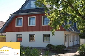 A red and white building with multiple windows and a covered porch area. - Holiday home in Zingst with swimming pool (Zingst)