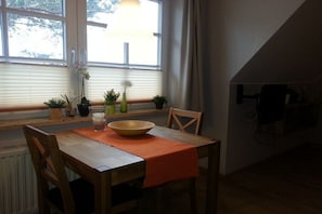 A dining area with a table, chairs, a bowl, and potted plants. - Apartment in Glowe with swimming pool (Glowe)