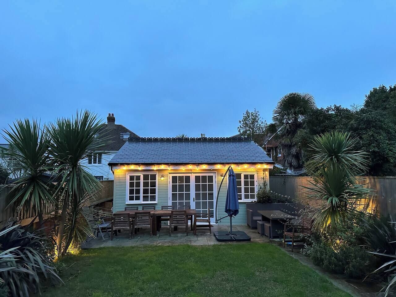 Ein Haus mit Terrasse, Essbereich und Garten.