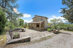 A stone building with a tiled roof, surrounded by a gravel courtyard and potted plants. - Your Authentic Chianti Escape in San Sano (San Sano)