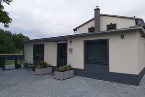A modern building with a flat roof, large windows, and a sign indicating a business or service. - Ecki's holiday home "Komm An de Bäk" (Alt Schönau)