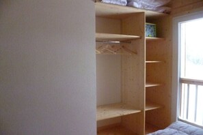 Ein Zimmer mit Holzschrank, Fenster und Bett.
