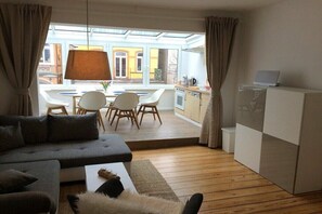 Ein modernes Wohnzimmer mit einer Couch, einem Couchtisch und einem Essbereich mit Stühlen und einem Tisch.