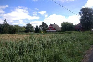 Ländliche Landschaft mit einer roten Scheune, einer Straße und einem Feld.