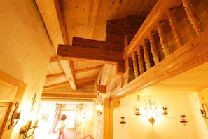 Ein Holzkamin mit Treppe, Holzbalken und Wandleuchten.