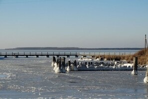 A frozen body of water with a pier extending into it. - Holiday home in Wiek with swimming pool (Wiek)