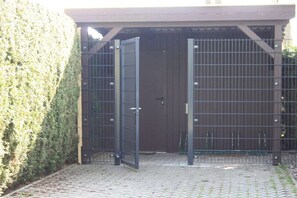 A gated entrance with a metal gate and a wooden structure in the background. - Holiday home with 1 bedroom (Trassenheide)