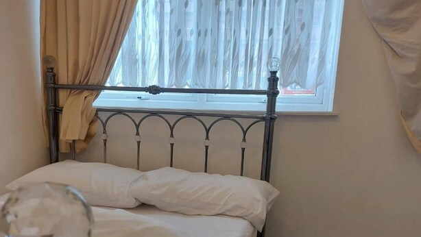A bedroom with a bed, a window with curtains, and a lamp with a crystal base. - Sunderland City Sr1 2ju - 2 Bedroom Apartment (Sunderland)