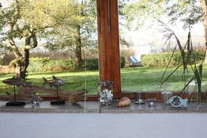 Eine Schaufensterdekoration mit dekorativen Elementen, darunter Fischskulpturen, ein Glas und eine Muschel.