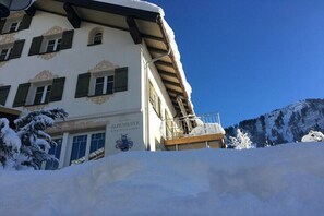 A building with snow-covered surroundings, a balcony, and a sign that reads 'ALPENSUIETE.' - Holiday apartment with 1 bedroom (Riezlern)