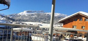 A wooden building with a sign 'Gonfleur-St. Moritz' and a view of snow-covered mountains. - Holiday apartment with 1 bedroom (Riezlern)