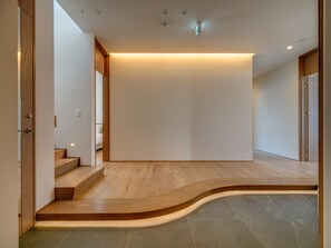 A modern interior with a curved wooden staircase leading to a flat ceiling. - Bisei (Kutchan)