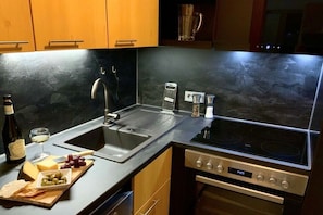 Une cuisine moderne dotée d’un évier à deux bacs, d’une cuisinière encastrée et d’un lave-vaisselle.