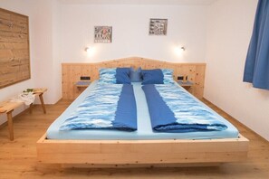 Ein Einzelbett mit Holzrahmen, zwei Nachttische und eine Wandleuchte.