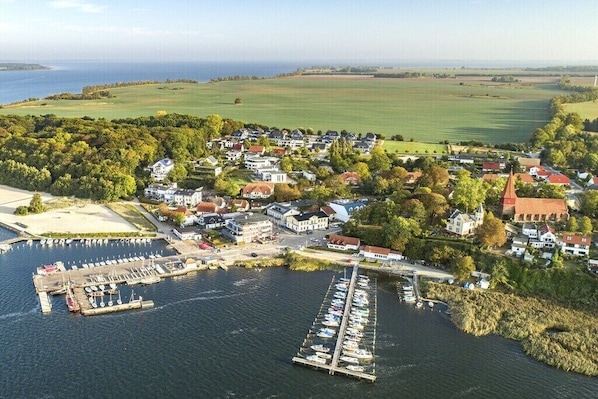 Ein Küstendorf mit einem Hafen, Häusern und einer Kirche.