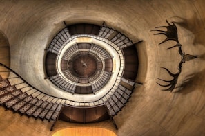 Eine Wendeltreppe mit einer zentralen Säule und verzierter Geländer.