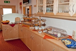 A buffet setup with various food items and glassware. - Edelweiss Guesthouse in the Ötztal Valley (Sautens)