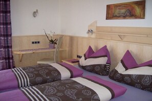 A hotel room with two beds, a desk, a chair, a potted plant, and a painting on the wall. - Apartment in Leogang with swimming pool (Leogang)