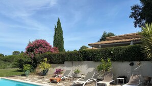 A swimming pool with lounge chairs and potted plants. - Beautiful contemporary architect-designed home with a pool and garden set amid the garrigue (Nîmes)