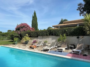A swimming pool with lounge chairs and potted plants. - Beautiful contemporary architect-designed home with a pool and garden set amid the garrigue (Nîmes)