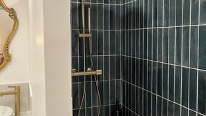 A bathroom with a shower, a sink, and a mirror. - Le Cantilien (Chantilly)
