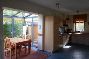 A kitchen with a dining table, chairs, and a window. - Holiday home with 1 bedroom (Ostseebad Rerik)