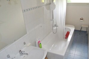 A bathroom with a bathtub, a sink, and a toilet.