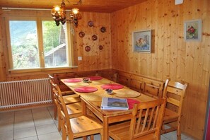 Un coin repas en bois, avec une table, des chaises et un radiateur.