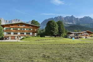 A hotel with multiple floors, balconies, and a mountainous backdrop.