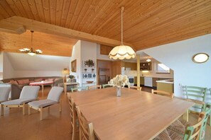 A spacious living area with a wooden dining table, chairs, and a hanging light fixture. - Cottage/Chalet Mag. Scholz (Seeboden am Millstättersee)
