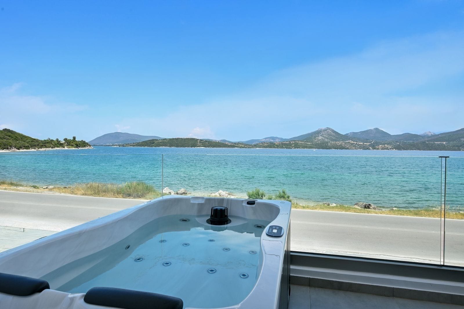 Een jacuzzi met uitzicht op een meer en bergen op de achtergrond.