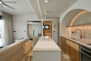 A modern kitchen with a central island, wooden cabinets, and a stainless steel sink.