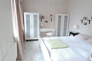 Ein Schlafzimmer mit einem Bett, einem Schreibtisch und zwei Kleiderschränken.
