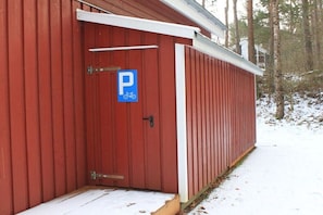 A red building with a blue parking sign and a bicycle symbol. - Beach House Deichkrone (Baabe)