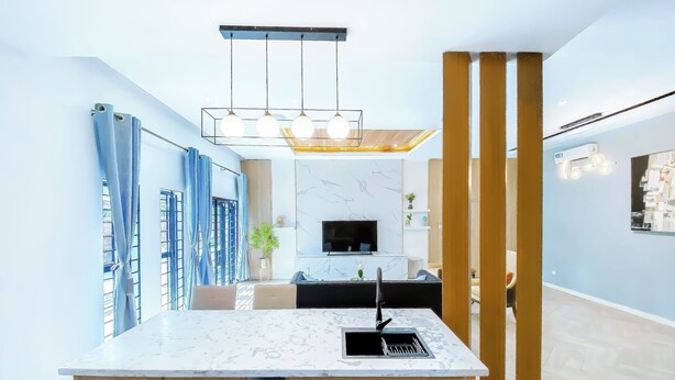 A modern kitchen with a marble countertop, wooden cabinets, a built-in sink, and pendant lighting. - 3 beds Villa with BBQ grill and very fast wifi (Douala)