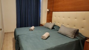 Una camera d'albergo con un letto, due cuscini e un comodino.