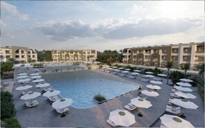 A hotel with a central swimming pool surrounded by sun loungers and umbrellas, with multiple-story buildings in the background. - SUNRISE Makadi Boutique  Resort (Makadi Bay)