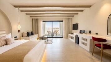 A modern hotel room with a large bed, a desk, a TV, and a balcony with a view.