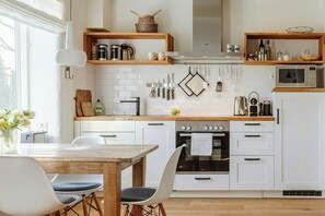 Eine moderne Küche mit weißen Schränken, Holz Arbeitsplatten und einem eingebauten Backofen.