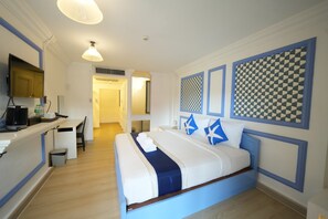 Een hotelkamer met een bed, bureau en stoel.