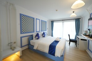 Een hotelkamer met een bed, een bureau, een stoel, een telefoon en een raam met gordijnen.