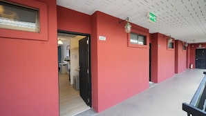 Un pasillo con paredes rojas, un letrero que indica 'EXIT 172' y una escalera a la derecha.