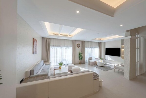 A modern living room with a sofa, coffee table, and TV.