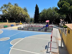 A playground with a basketball court, swings, and a climbing structure. - Torremolinos Sky View: The city at your feet. (Torremolinos)