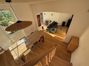 A modern interior with a dining area, a sofa, and a view of the outdoors. - Los Arcos | Two renovated houses for 15 people. 4-legged friends too! (Annonay)