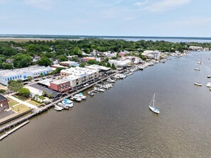 A marina with boats docked along a waterfront, surrounded by buildings and greenery.