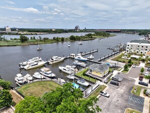 A marina with boats docked, a parking area, and a building with a flat roof. - Harbor View Suite B in Historic Georgetown (Georgetown)
