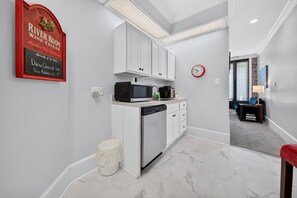A modern kitchen with white cabinetry, a built-in microwave, and a dishwasher. - Harbor View Suite B in Historic Georgetown (Georgetown)